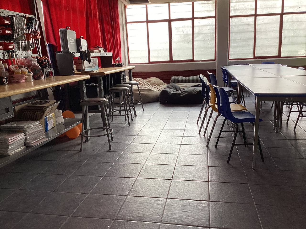 Aula maker con mesas de trabajo y materiales