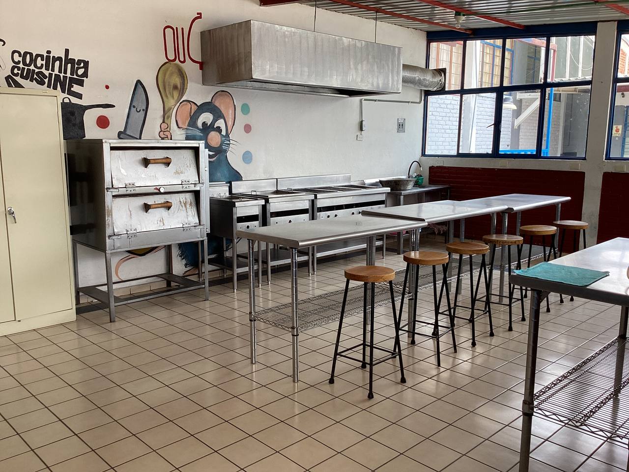 Aula de gastronomía con mesas y equipo de cocina
